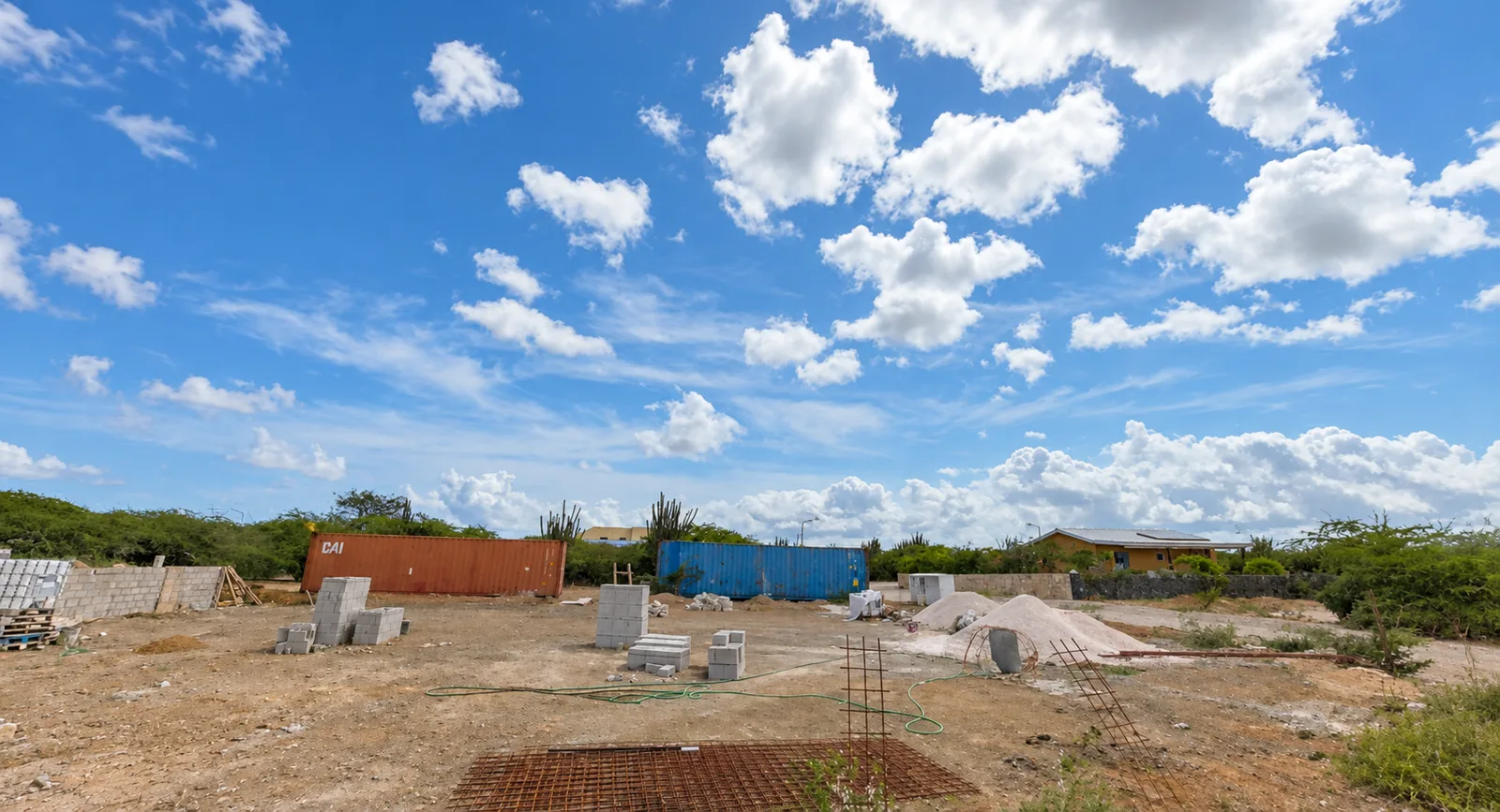 Voorbereid terrein met bouwmaterialen en transportcontainers